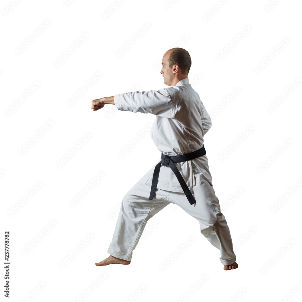 Black belt athlete trains formal karate exercises on white isolated background Black belt athlete trains formal karate exercises on white isolated background