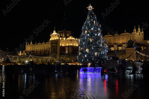 Krakow city center at night, big Christmas tree, historical building illuminated, Christmas market, reflections 