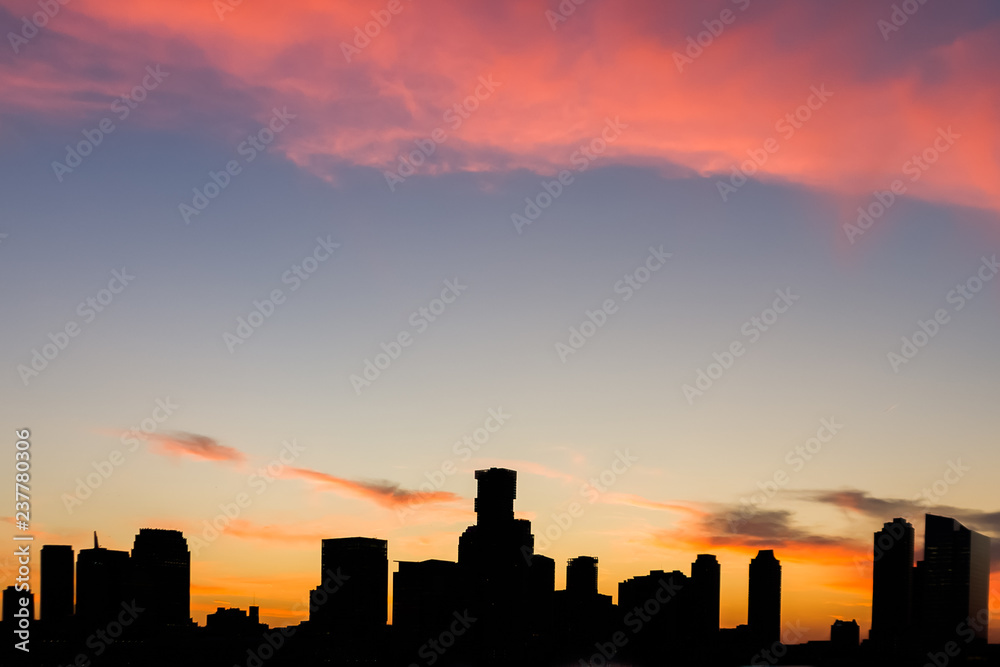 Sunset in the city with colorful sky, red clouds and dark silhouette of the Jersey City, New Jersey