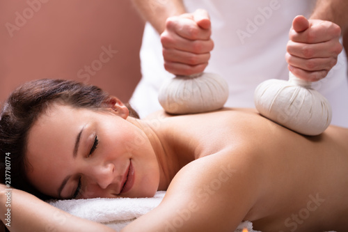 Therapist Giving Massage With Herbal Compress Balls To Woman Fotobehang