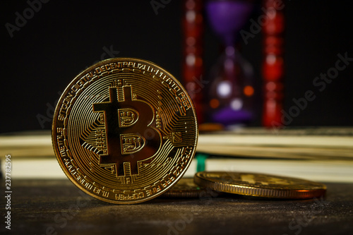 Hourglass with wad of dollars and gold coins in the form of bitcoin