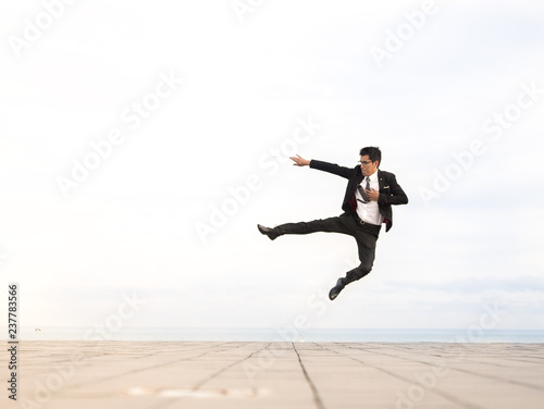 man wearing suit jumping outdoor