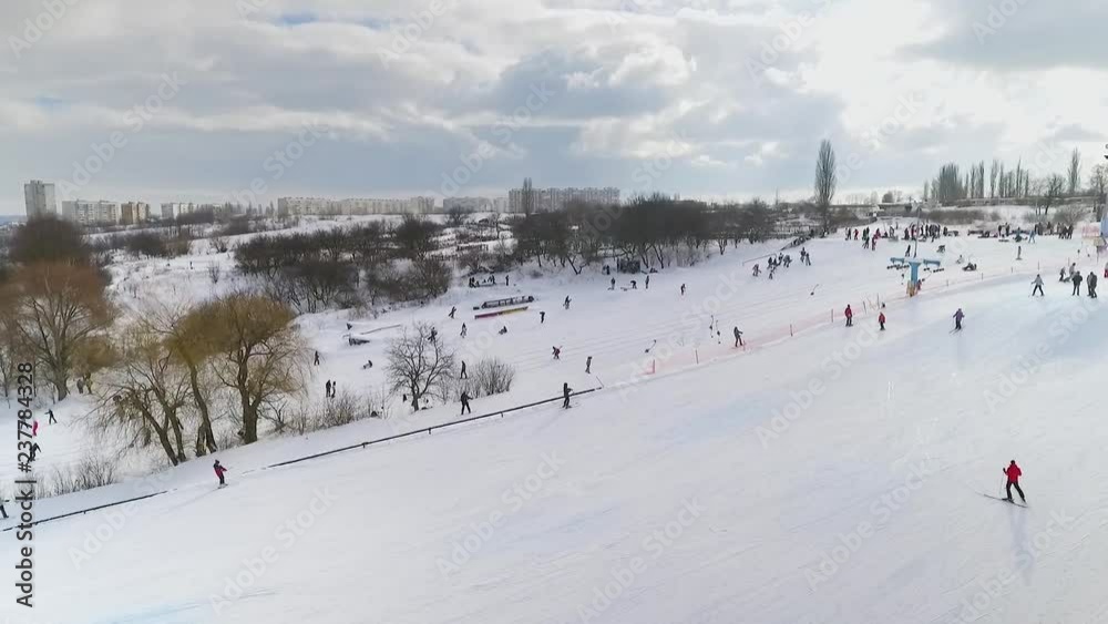 aerial of skiers and snowboarders sliding down snowy slope and riding up with ski lift . winter sports, leisure activities, healthy lifestyle aerial of skiers and snowboarders sliding down snowy slope and riding up with ski lift . winter sports, leisure activities, healthy lifestyle