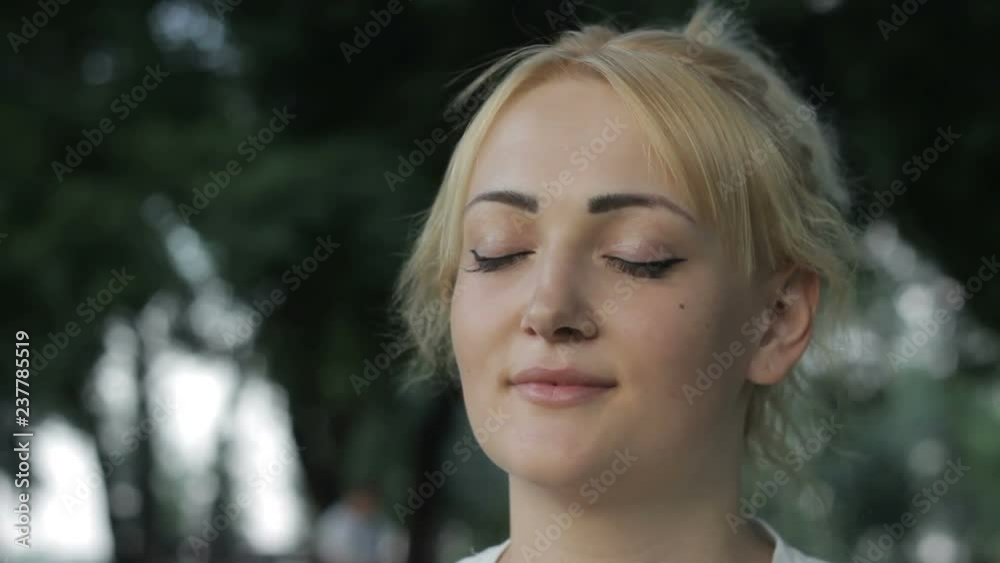 Young, gorgeous blond lady standing, fresh air in forest, light breeze blowing Young, gorgeous blond lady standing, fresh air in forest, light breeze blowing