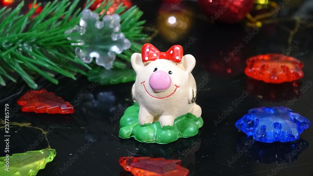 Merry Christmas and happy New year. Chinese new year of the Pig, symbol 2019 for greetings card. soft selective focus. Toy pig in the branches of spruce. Background with copy space. Selective focus.