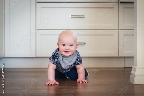 infant crawling in kitchen