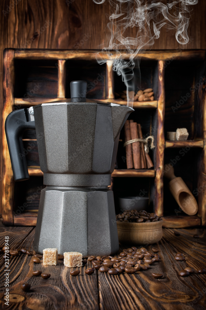 Steaming geyser coffee maker and roasted beans with wooden box on rustic background Steaming geyser coffee maker and roasted beans with wooden box on rustic background