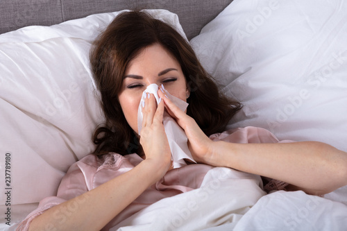 Sick Woman Sneezing In Handkerchief