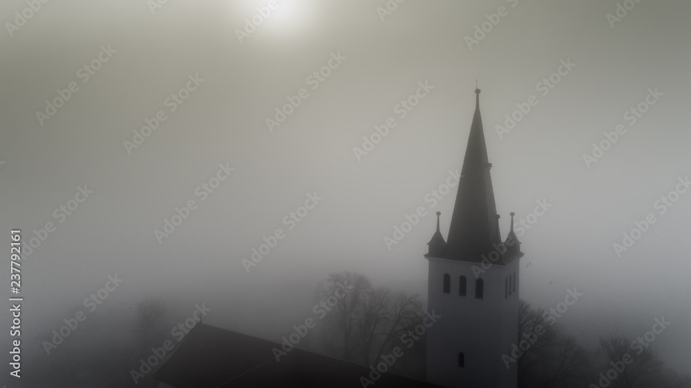 Aerial view  about the beautiful catholic church on a foggy morning In Sic village, Transyvania, Romania