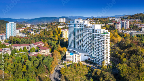 Apartment house white on the background of mountains and forests in the neighborhood bytha in Sochi. Residential area, city area, apartments by the sea.