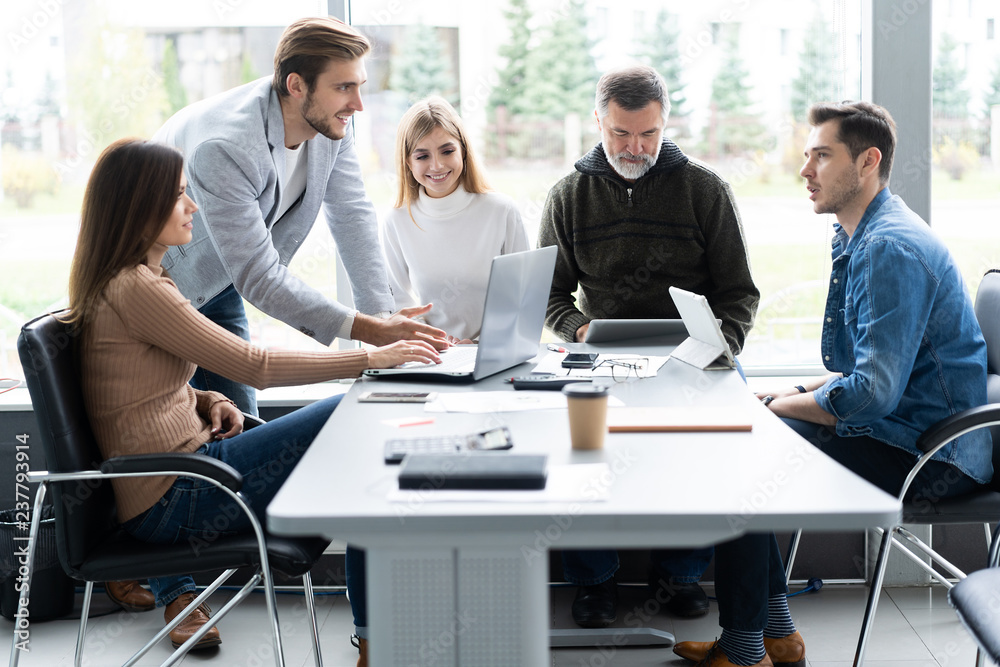 © opolja - Sharing opinions. Group of young modern people in smart casual wear discussing business while working in the creative office. © opolja - Sharing opinions. Group of young modern people in smart casual wear discussing business while working in the creative office.