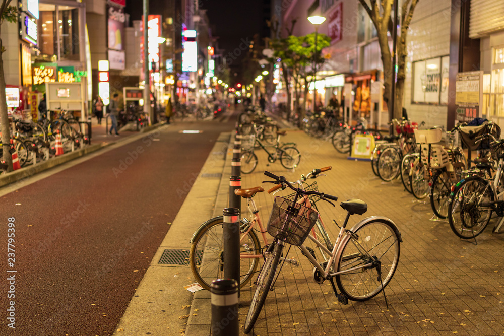 Rows of bicycles line city street at night
