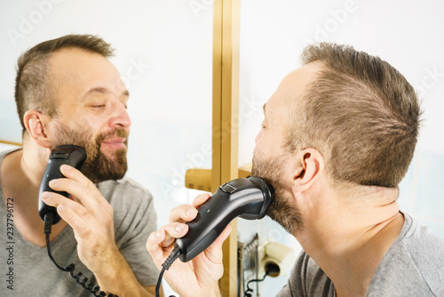Man shaving trimming his beard