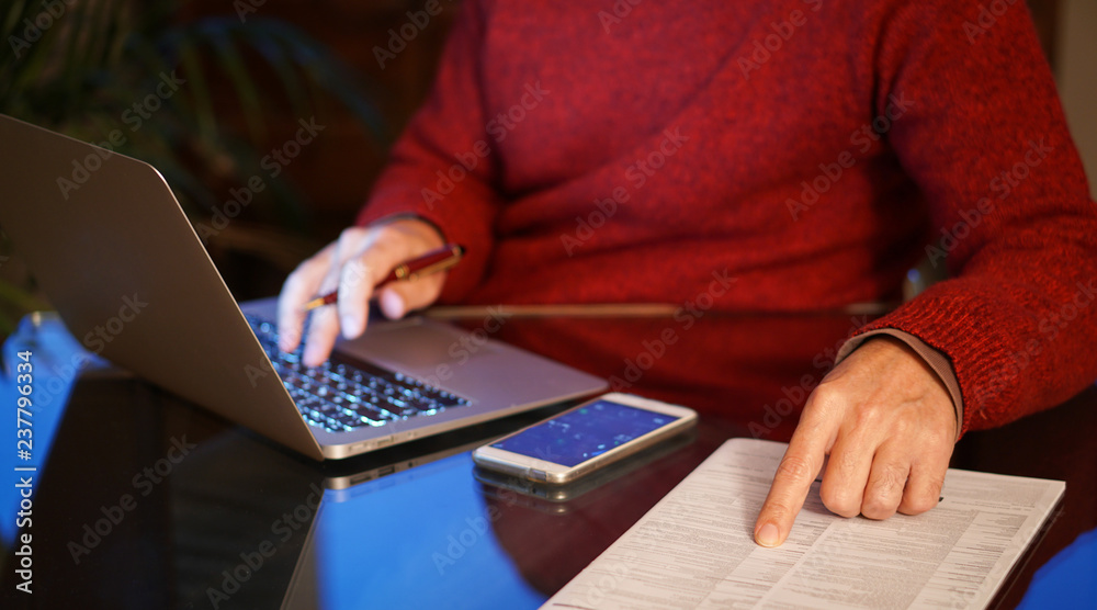 Man using laptop and pointing to a pressed sheet Man using laptop and pointing to a pressed sheet