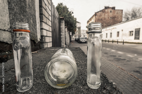Fototapeta Naklejka Na Ścianę i Meble -  3 empty small alcohol bottles on the empty street in Warsaw, Poland
