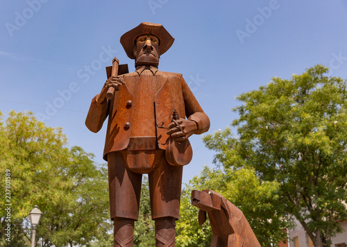 rusty statue of a farmer and his dog in La Puebla de Almoradiel town, province of Toledo, Castilla-La mancha, Spain photo