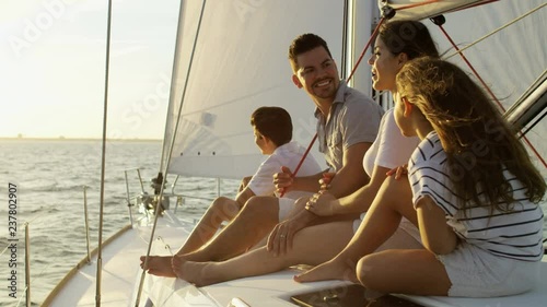 Young ethnic Latino family enjoying carefree lifestyle sailing the ocean on luxury yacht in the Summer sun 