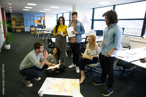 Startup business people in modern office. Group of young business people are working together with laptop. Freelancers sitting on the floor. tech startup, tech team.