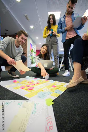 Startup business people in modern office. Group of young business people are working together with laptop. Freelancers sitting on the floor. tech startup, tech team.