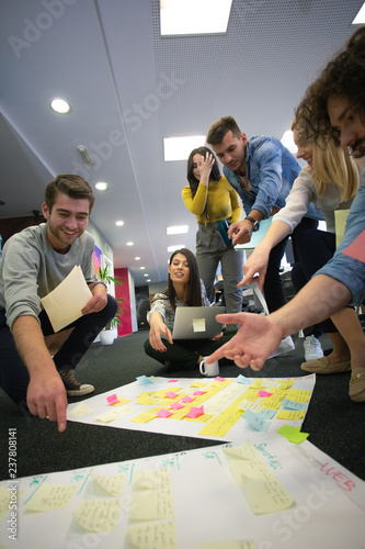 Startup business people in modern office. Group of young business people are working together with laptop. Freelancers sitting on the floor. tech startup, tech team.