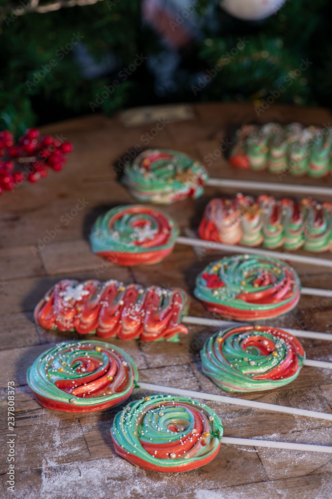 Various Christmas sweets and candies with christmas tree on wood table