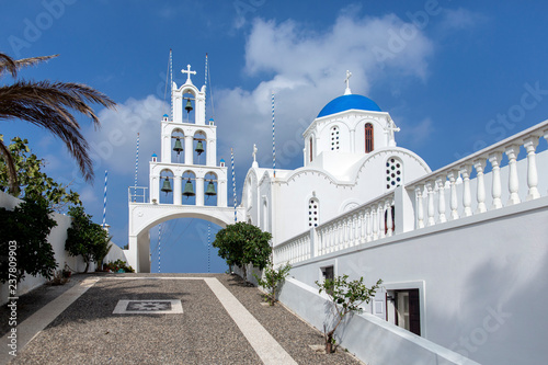 Very beautiful Orthodox church in the city of Karterados on the island of Santorini. Typical white church on Santorini. Photo of a greek church in Santorini and the blue sky