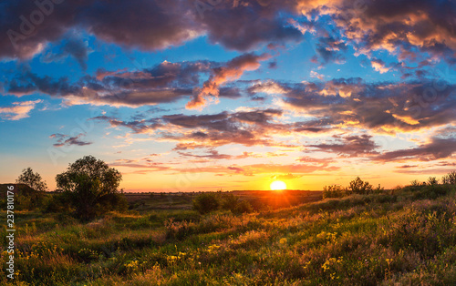 Summer bright landscape. Cloudy sunset over the steppe hills. Cloudy sky and sunlight. Ukrainian landscape. Kriviy Rih