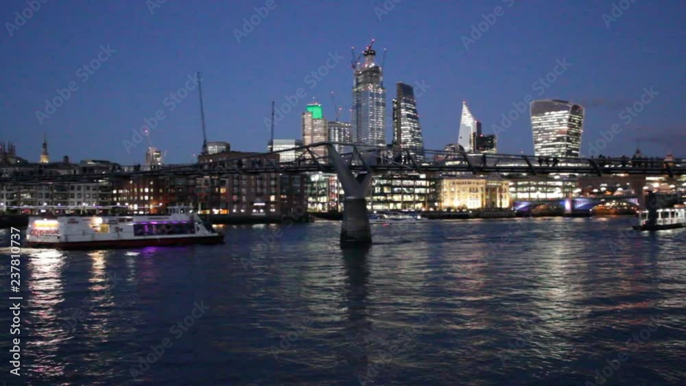Millenium bridge view across the Thames river London, England, UK footage film video of river ripple s and people walking over the bridge both are popular tourist/tourism landmarks on the landscape of Millenium bridge view across the Thames river London, England, UK footage film video of river ripple s and people walking over the bridge both are popular tourist/tourism landmarks on the landscape of
