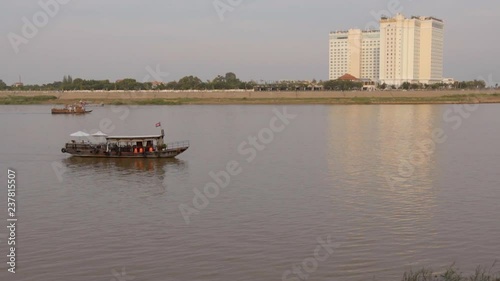 Boats going across the Mekong River in Phnom Penh, Cambodia photo