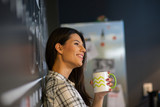 Young beautiful business woman drinking her coffee and smiling in the kitchen 