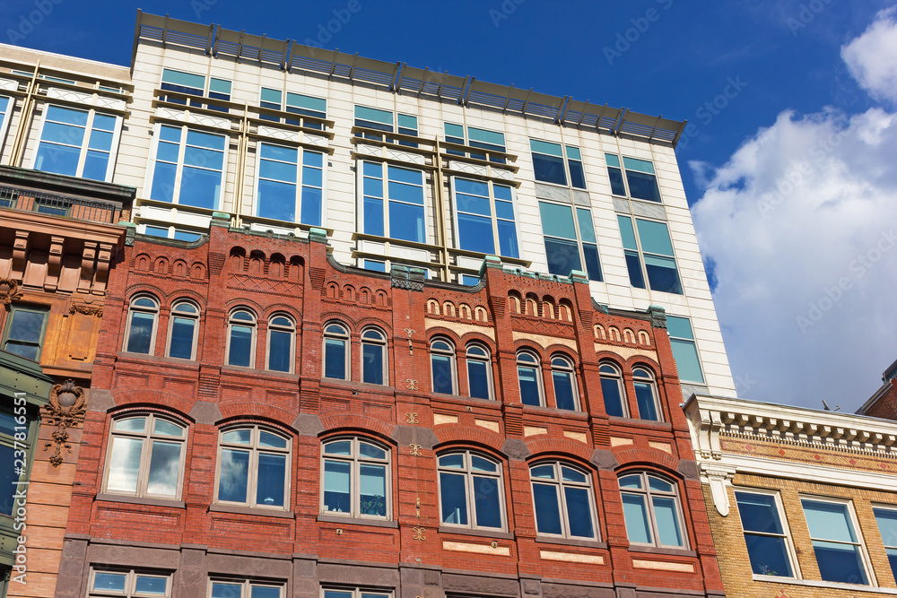 Naklejka premium Washington DC buildings, coexistence of different styles in urban architecture. Beautiful buildings under a blue sky with cumulus clouds in US capital.