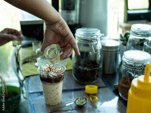 Hand of Barista preparing cappuccino with iced coffee