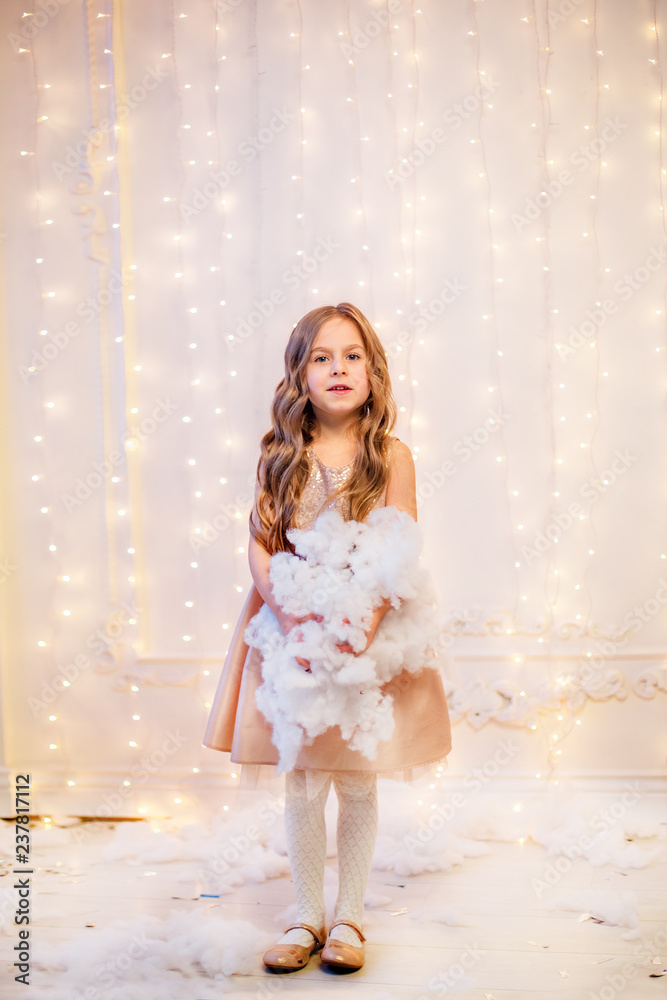 Portrait of a little girl with curly hair on Christmas Eve, the New Year will bring gifts. Portrait of a little girl with curly hair on Christmas Eve, the New Year will bring gifts.