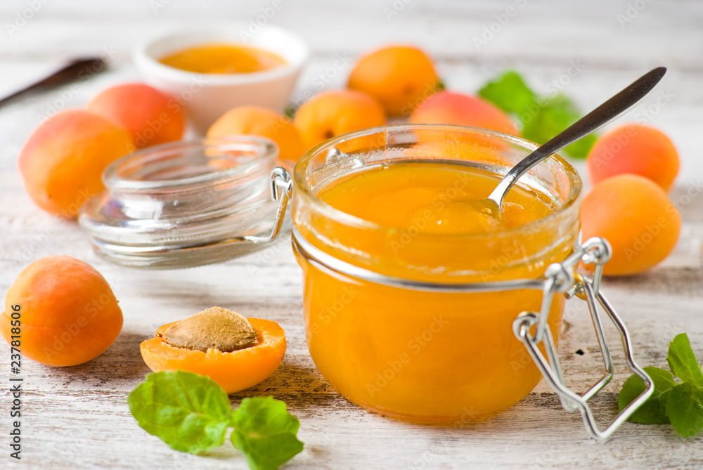 jar with homemade apricot jam on a light wooden background jar with homemade apricot jam on a light wooden background