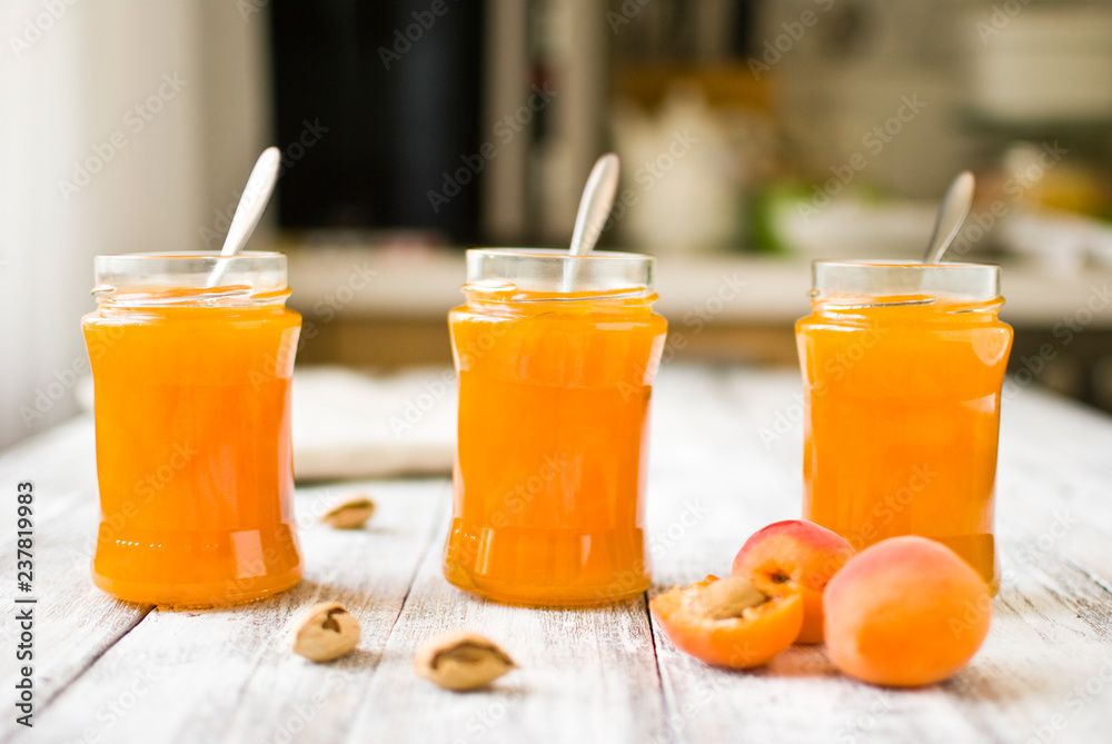 jar with homemade apricot jam on a light wooden background