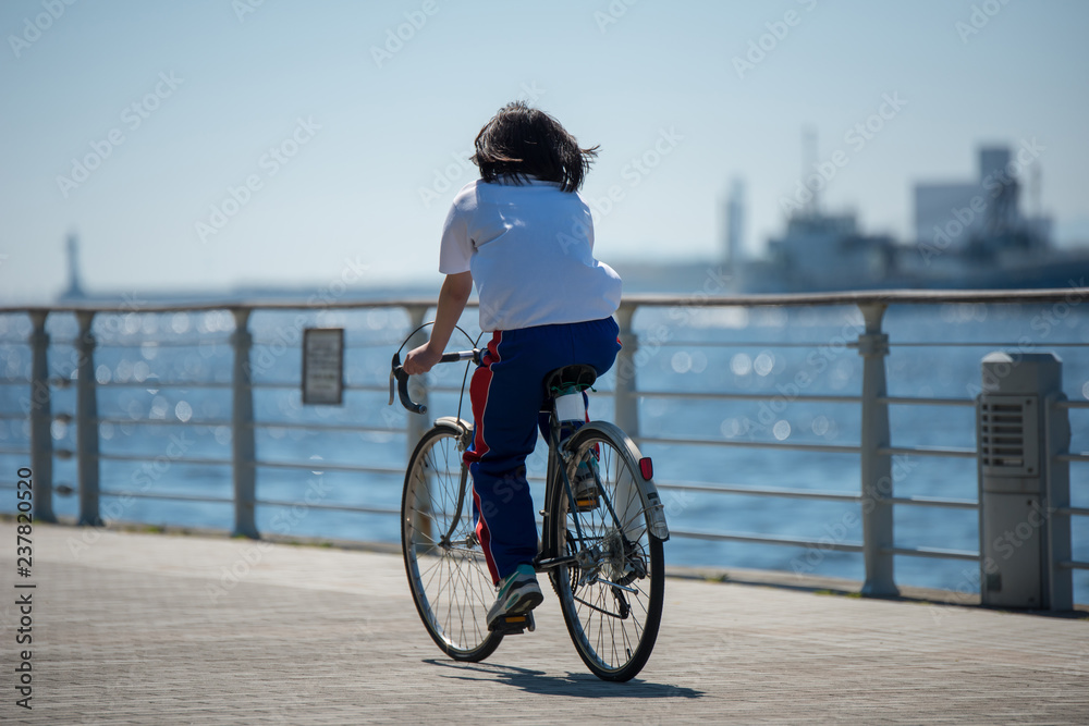 自転車で海辺を走る少女