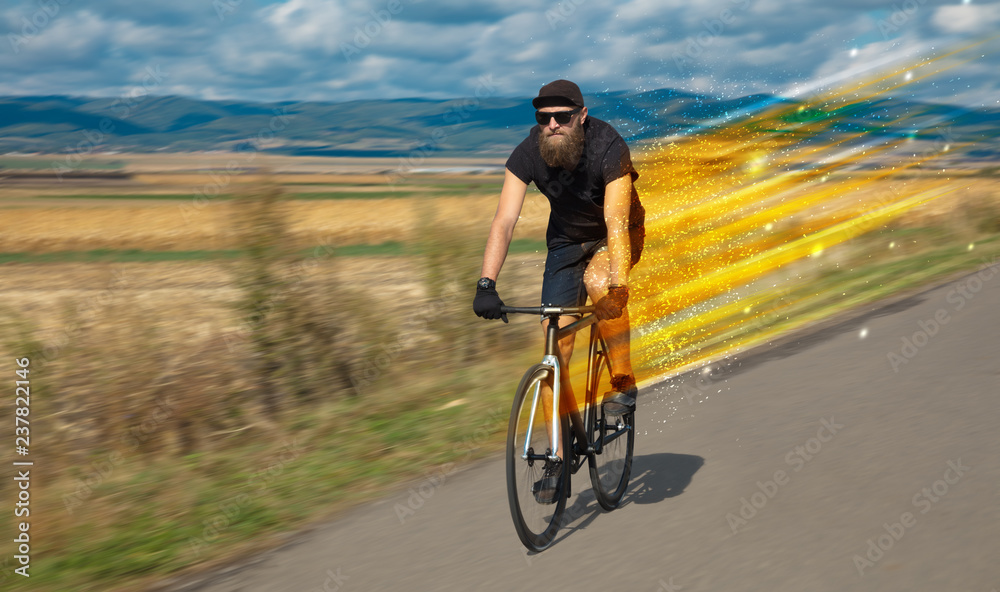 Fototapeta premium Young riding bicycle in fabulous nature with high speed