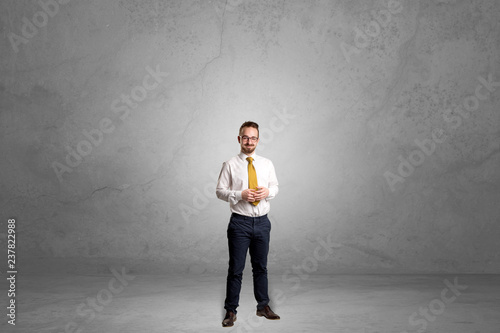 Alone handsome businessman standing in a dark empty room