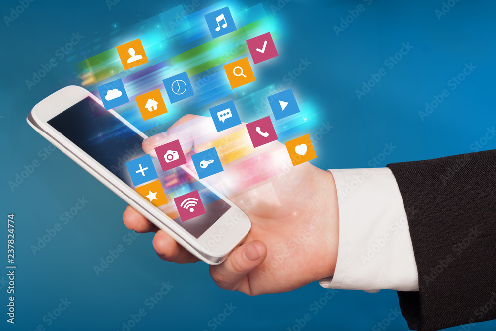 Hand using phone with colorful fast moving application icons and symbols concept
