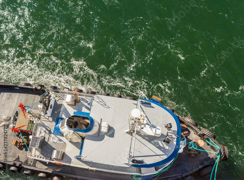 Overhead view of tugboat, ropes and workers assisting ship to dock, Alaska, USA. © illuminaphotographic