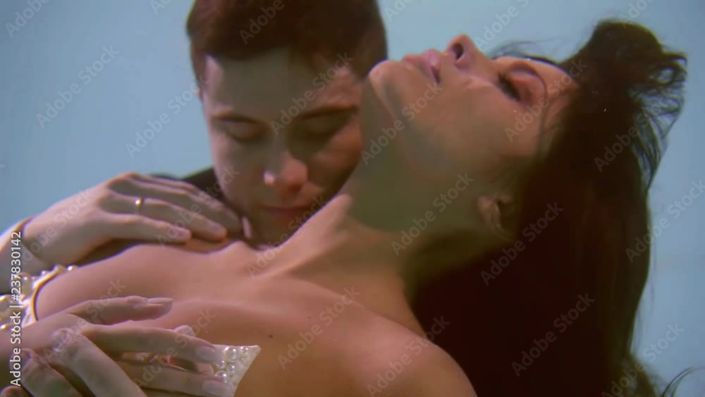 close up. a man gently touches his wife on the wedding day. they float under water like in a fairy tale