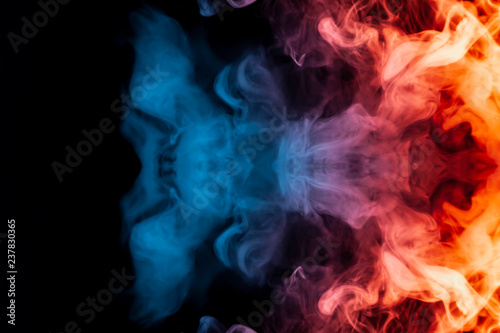 A dynamic explosion of puffs of smoke of light blue orange and red colors swirl on a black background with tongues of flame an isolated pattern in the form of a medusa.