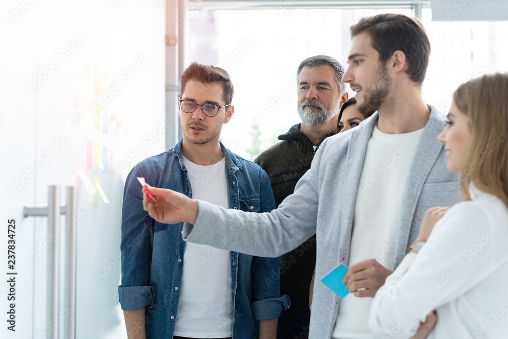 business, education and office concept - business team with flip board in office discussing something business, education and office concept - business team with flip board in office discussing something