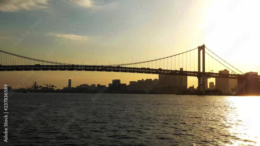 At dusk, The boat goes beside the skyscraper and the bridge in Tokyo At dusk, The boat goes beside the skyscraper and the bridge in Tokyo
