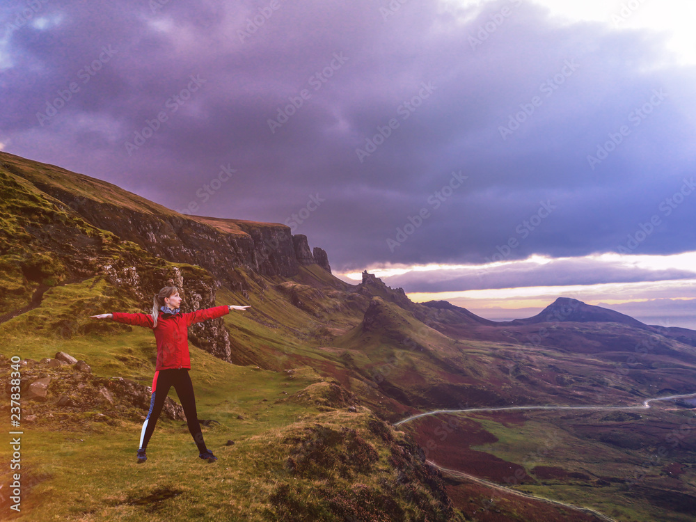 Concept of young lady doing yoga exercises outdoors on the Quiraing in Scotland
