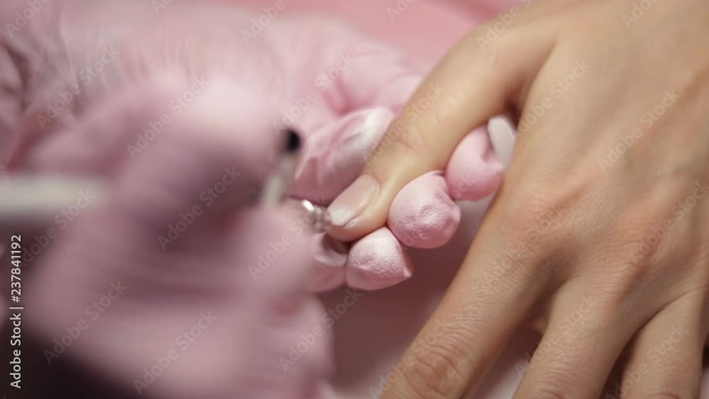 Master makes manicure with airbrush in white Master makes manicure with airbrush in white