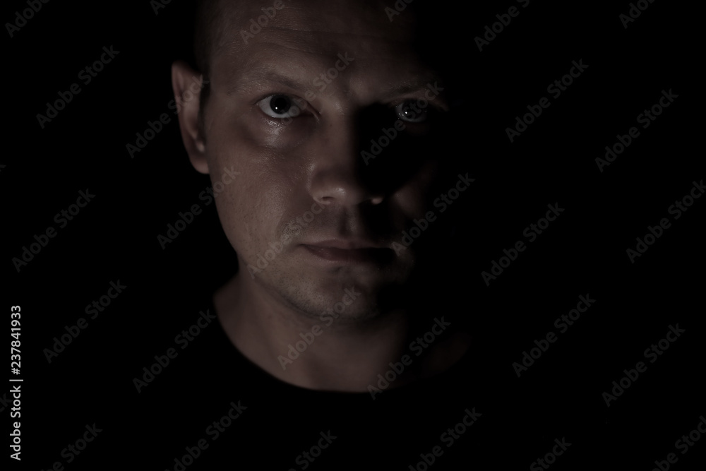 Portrait of a serious man face in darkness. Portrait of a serious man face in darkness.
