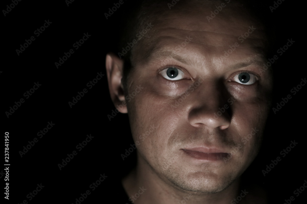 Portrait of a serious man face in darkness. Portrait of a serious man face in darkness.