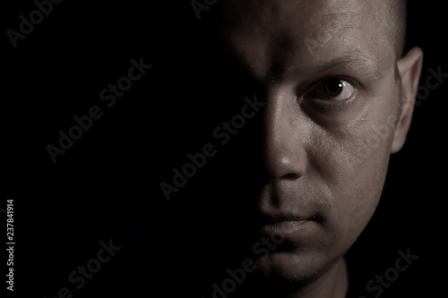 Φωτογραφία Portrait of a serious man face in darkness.