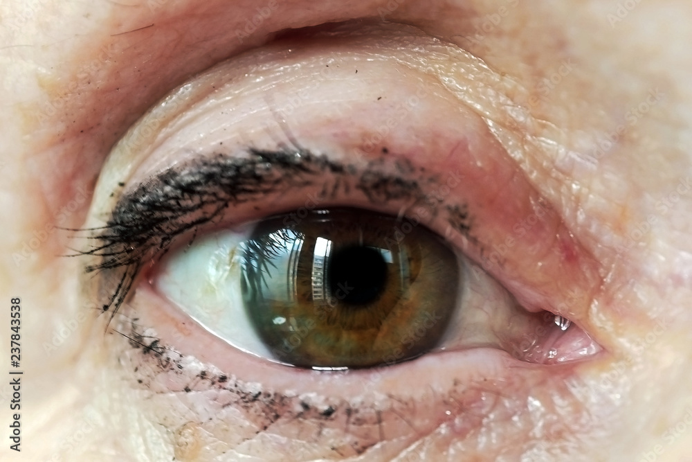 Fototapeta premium Eye open old grandmother. View eyes of an elderly woman macro.